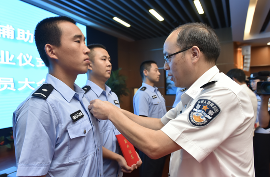 杭州市公安局相關負責人為輔警人員授警號. 杭州警方 供圖