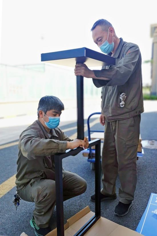 图为伊水湾物业工作人员更换小区标识牌.