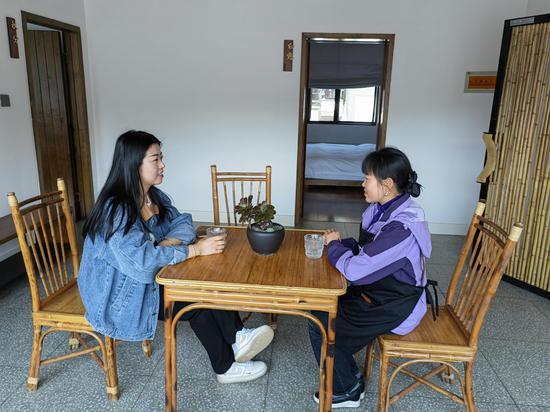 彭州市桂花镇金城社区小石记·山宿工作人员(右)与游客在聊天(摄于