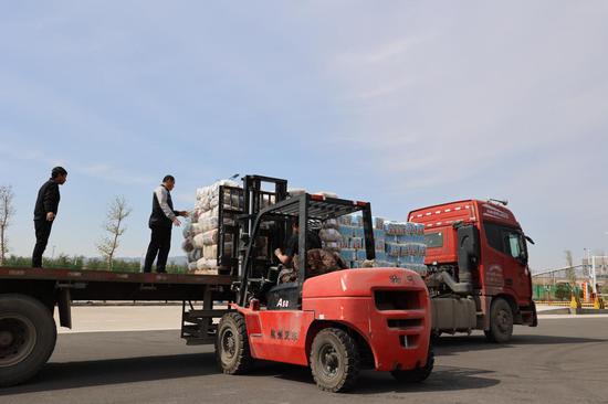 在阿拉山口边民互市一级市场展销中心,工人正在卸货.文亚辉 摄