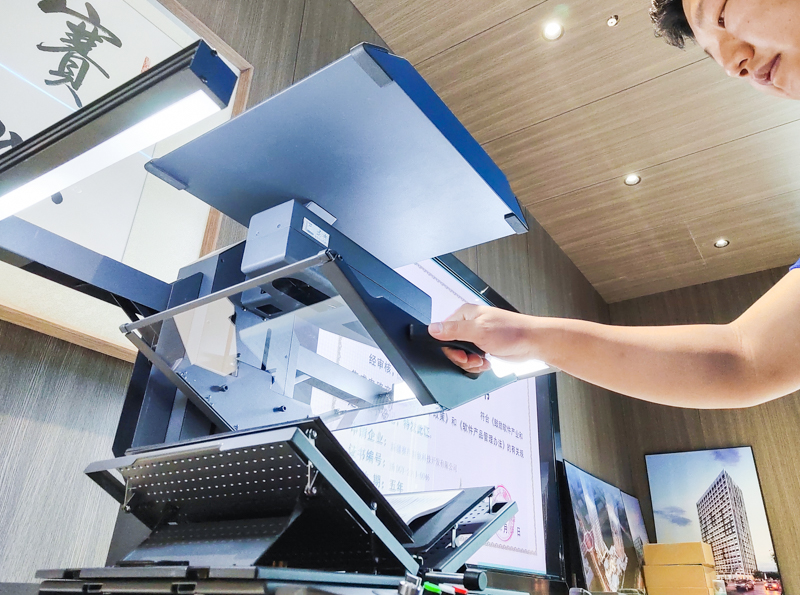 在新疆赛昂新软科技开发有限公司,工作人员操作全自动免拆除档案书刊