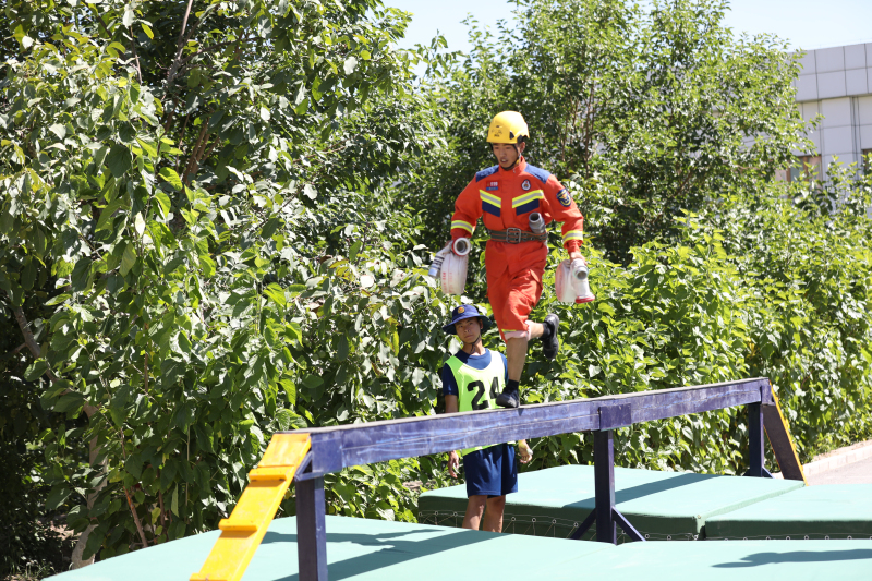 图为参赛队员参加百米消防障碍科目竞赛.