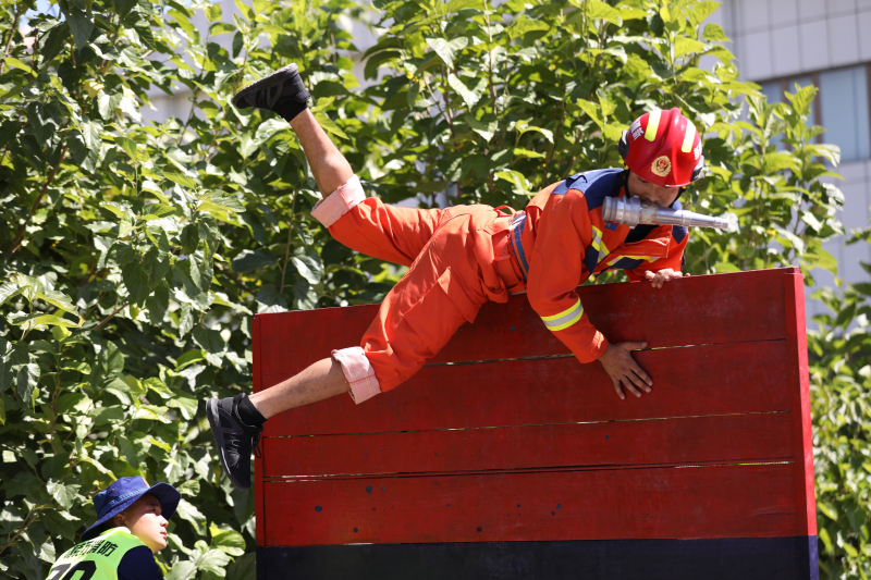 图为参赛队员正在参加百米消防障碍竞赛科目.