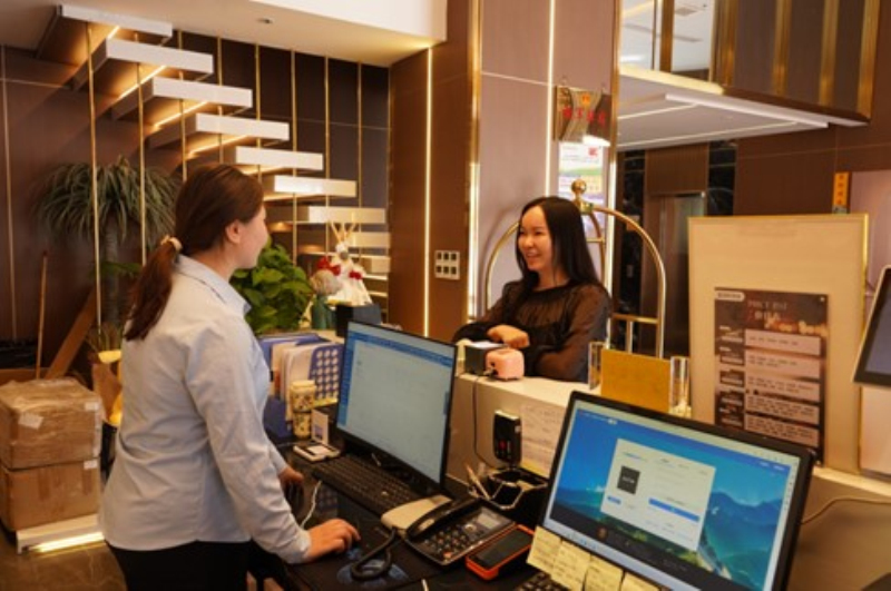 工作人员正热情地为前台预约办理入住手续的游客提供服务.