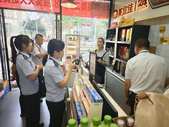 图为宜州烟草组织党员干部联合市监、公安部门开展烟草市场专项检查。韦镔 摄