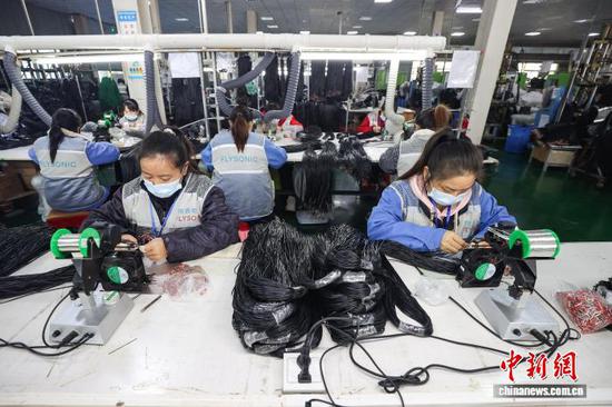 11月13日，工人在拼装耳机零部件。中新社记者 瞿宏伦 摄