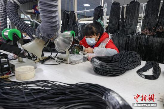 11月13日，工人在拼装耳机零部件。中新社记者 瞿宏伦 摄