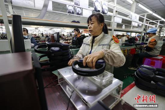 11月13日，工人在测试待出厂耳机。中新社记者 瞿宏伦 摄