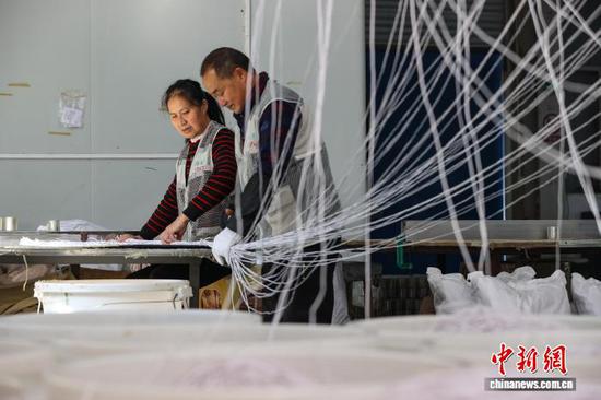 11月13日，工人在剪裁耳机线。中新社记者 瞿宏伦 摄
