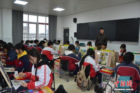 图为番禺班美术老师在检查学生作业。刘虹艳 摄