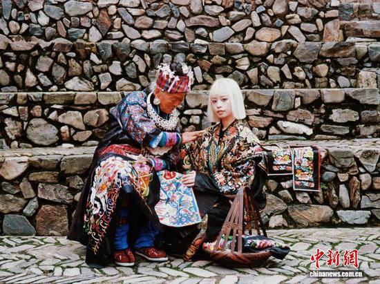 图为张理月(右)和苗族绣娘在一起。(受访者供图)