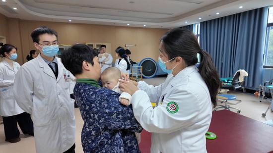 肖克医生查看儿童健康情况。胡倩 摄