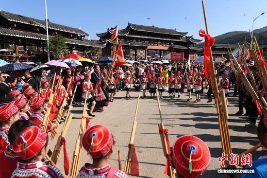 图为芦笙会巡游过程中，苗族女孩表演跳芦笙。陈孝新 摄