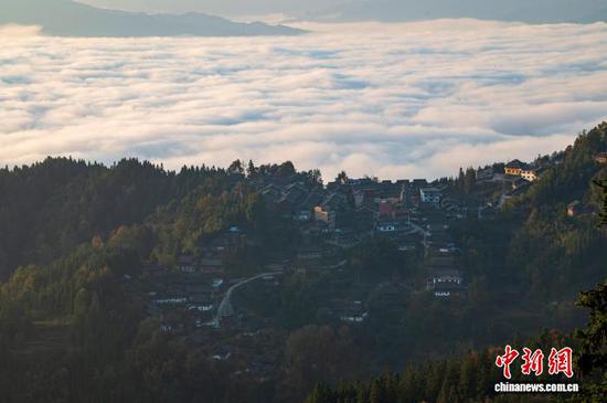 初冬时节，贵州省黔东南苗族侗族自治州从江县高增乡天鹅山出现云海景观，侗寨民居、田园风光与蜿蜒公路在云海中若隐若现，构成一幅诗意生态画卷。图为11月25日在天鹅山航拍的云海景观。吴德军 摄