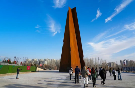 参加“跟着‘左公’看哈密”主题采访活动的媒体记者在哈密市左宗棠凤凰台历史文化公园天地正气塔前参观、采访。融媒体中心记者 李华摄