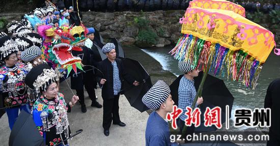 11月25日，在松桃苗族自治县盘石镇响水洞村，村民在举行“接龙”活动。 谢慧芳摄