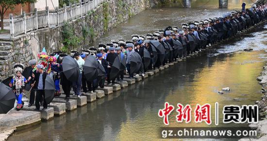 11月25日，在松桃苗族自治县盘石镇响水洞村，村民在举行“接龙”活动。谢慧芳摄