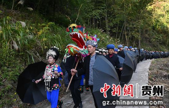 11月25日，在松桃苗族自治县盘石镇响水洞村，村民在举行“接龙”活动。谢慧芳摄