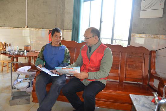 图为辖区客户经理（右一）梁韫正在和杜庆仁沟通芦笙制作工艺。吴俊鹏 摄