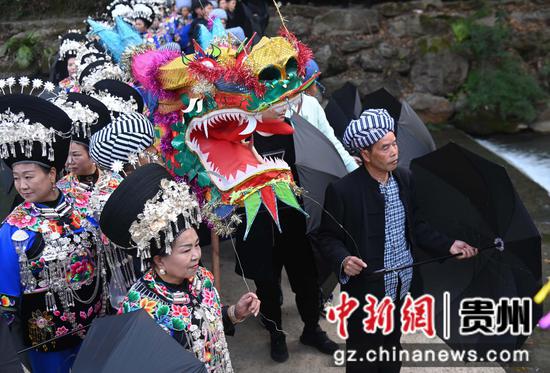 11月25日，在松桃苗族自治县盘石镇响水洞村，村民在举行“接龙”活动。 谢慧芳摄