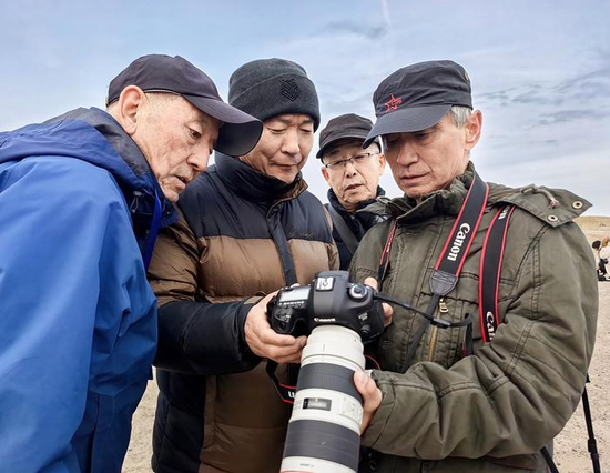 11月20日，创作归来的摄影师正在交流作品。克拉玛依融媒记者 闵勇 摄