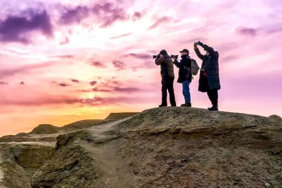 11月20日，3名摄影师在世界魔鬼城景区的一处土丘上取景。克拉玛依融媒记者 闵勇 摄