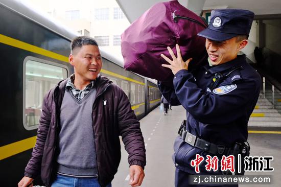 图为：铁警化身“搬运工”，帮旅客扛起行囊暖人心。中新社发 贺瑞明 摄