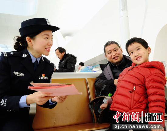 图为：铁警向小旅客普及安全知识，笑容点亮出行路。中新社发 贺瑞明 摄