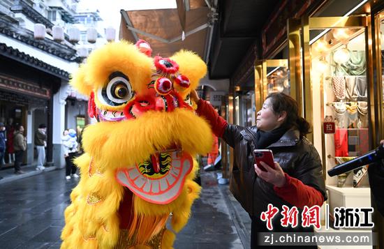 图为：商户摸狮头、沾喜气。中新社记者 王刚 摄
