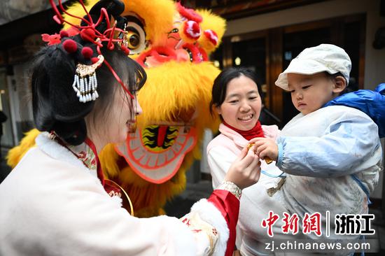 图为：嘉年华巡游人员和孩童互动。中新社记者 王刚 摄