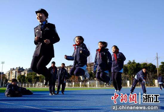 图为：海宁志摩小学的操场上，铁警与孩子们欢乐跳绳。中新社发 贺瑞明 摄
