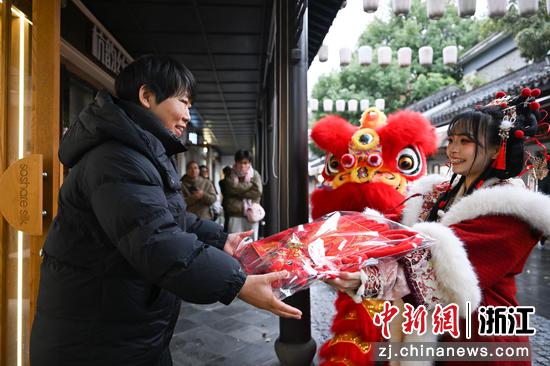 图为：嘉年华巡游人员向商户送福。中新社记者 王刚 摄