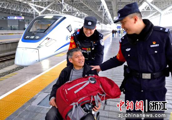 图为：铁警暖心帮扶旅客，和谐号旁定格温情瞬间。中新社发 贺瑞明 摄