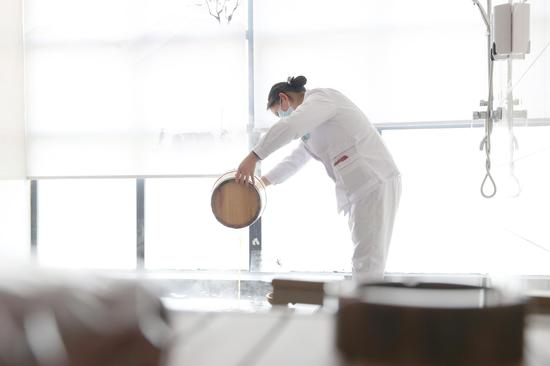 医务人员将调配好的特制中药汤剂注入浴池。唐鹏 摄