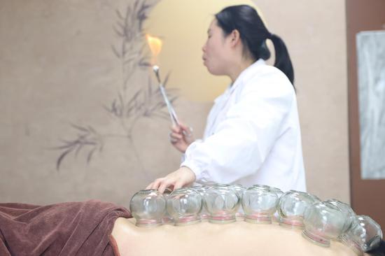 中医师在给做完药浴的游客拔火罐。唐鹏 摄