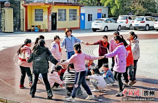 安凤与“大山里的小诗人”一起做游戏。凤冈融媒供图