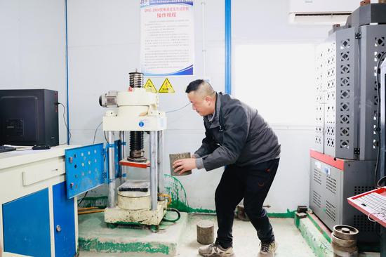 S306仁怀市茅坝至龙井公路改扩建工程、道路试验检测员张明义正在做试验