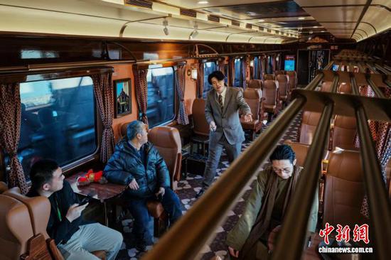 1月10日，旅客在开往北京站的“津旅时光号”列车上观看话剧片段演出。中新社记者 佟郁 摄