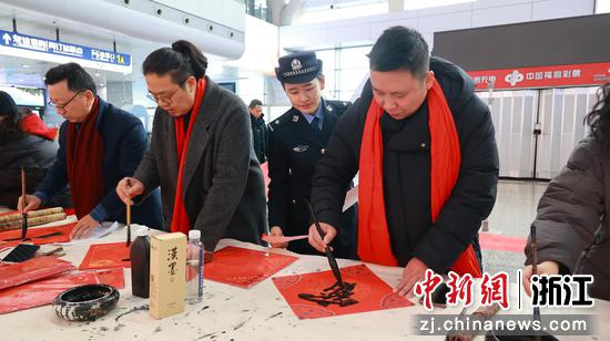 图为：书法志愿者为旅客写福。中新社发 黄沁 供图