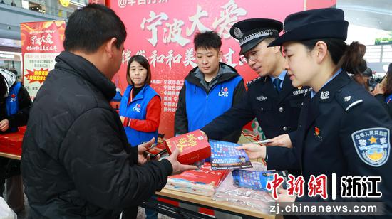 图为：民警向旅客赠送反诈资料和纪念品。中新社发 黄沁 供图