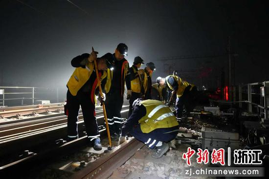 图为：工人们维护铁轨。中新社发 尹一凡 摄