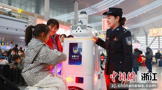 图为：民警向旅客介绍“机器人警员”。中新社发 黄沁 供图