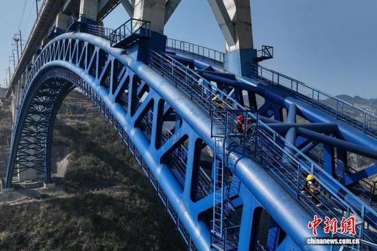 图为铁路桥隧工在西溪河大桥钢拱上进行检查作业。(无人机照片)中新社记者 瞿宏伦 摄