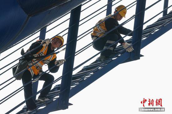 图为铁路桥隧工周韦(左)、顾英杰在钢拱架进行检查作业。中新社记者 瞿宏伦 摄