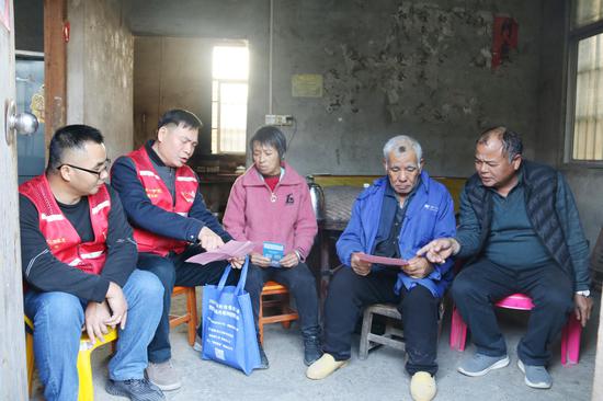 横州烟草派驻第一书记谢胜积（左二）向村民宣传乡村振兴帮扶政策。梁秋丽 摄
