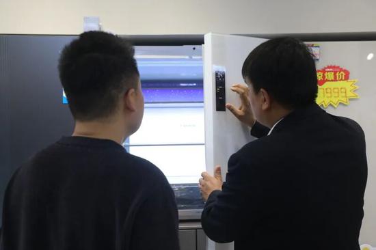 工作人员向顾客介绍冰箱性能。阿的拉 摄
