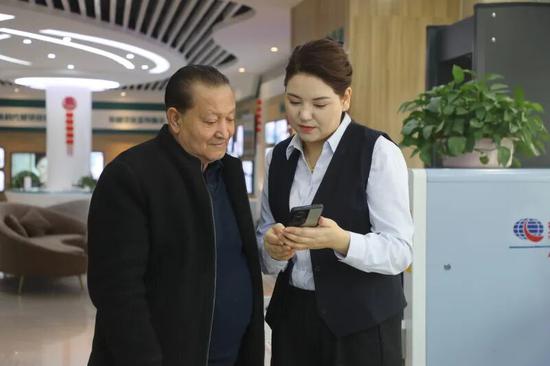 营业厅工作人员帮市民手机缴费。阿的拉 摄