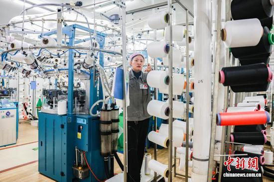 2月23日，工人在三穗县一家服饰企业的生产车间赶制无缝针织服装订单产品。龙兴伟 摄