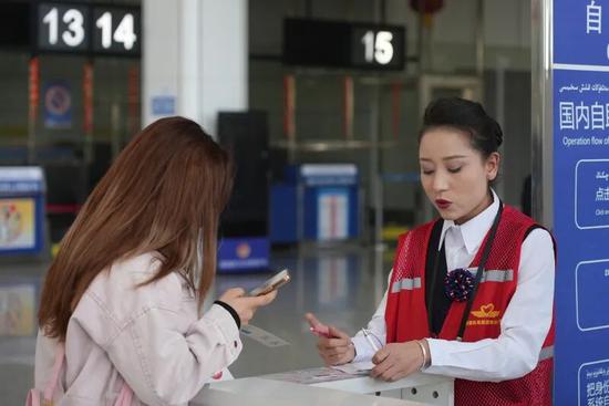 机场工作人员为旅客提供购票咨询服务。阿卜力克木 摄a