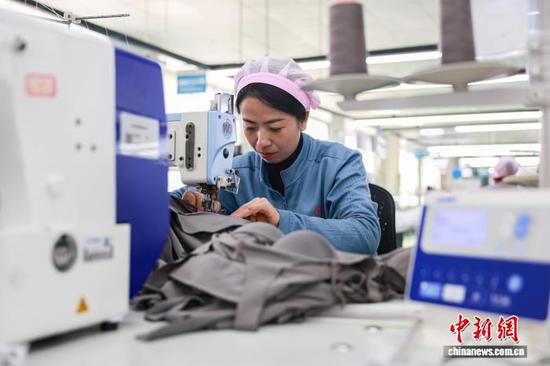 2月23日，工人在三穗县一家服饰企业的生产车间赶制服装订单产品。龙兴伟 摄